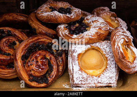 Frisch gebackenes Gebäck, Pudding, Aprikosen, Rosinen, Zimt Swirl in Puderzucker bestäubt und Glasur Stockfoto