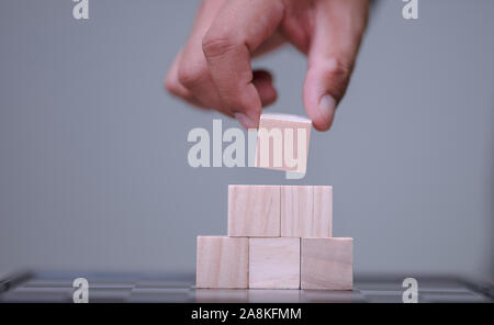 Hand und Organisation der Holzblock Stapeln wie Schritt Treppe mit Platz für Ihre Inhalte in Holzblock Stockfoto