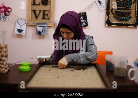 Gaza, Palästina. 09 Nov, 2019. Eine palästinensische Künstlerin Hala Abu Kaoud macht Kunst mit Kaffeebohnen an ihrem Haus im südlichen Gazastreifen Stadt Rafah und Märkte sie online. Abu Kaoud, 19, Studien Interior Design und bildende Kunst an der Universität in Rafah. Credit: SOPA Images Limited/Alamy leben Nachrichten Stockfoto