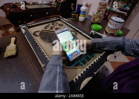 Gaza, Palästina. 09 Nov, 2019. Hala Abu Kaoud hält ein Mobiltelefon und zeigt Ihre Bilder online. Abu Kaoud, 19, Studien Interior Design und bildende Kunst an der Universität in Rafah. Credit: SOPA Images Limited/Alamy leben Nachrichten Stockfoto