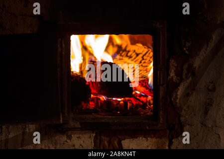 Brennende Flamme eines Ofens in einem russischen Dorf. Wärme und Behaglichkeit im Haus Stockfoto