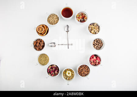 Ein Konzept oder eine kreative Idee, das heißt Tea Time. Nützliche Kräuter- oder grüner Tee in der Mitte und um die verschiedenen getrockneten Kräutern für seine Vorbereitung. Stockfoto