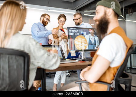 Gruppe von vielfältigen kreativen Menschen arbeiten als Webdesigner im modernen Büro, junges Paar entwerfen auf dem Computer Stockfoto