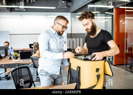 Kurier liefert frische Lebensmittel mit thermischen Tasche für ein büroangestellter. Konzept der Lebensmittel Auslieferung an die Mitarbeiter im Büro Stockfoto