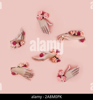 Legen Sie die Hände mit künstlichen Blumen aus Loch rosa Papier Hintergrund. Hand in verschiedenen Posen, das Muster layout für Ihre Collage. Kosmetik ha Stockfoto