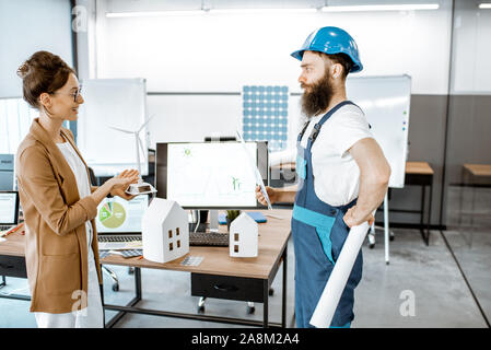 Männliche Arbeitnehmer und Frau Engineer, der an ein Projekt der alternativen Energie, wind turbine Modell im Büro Stockfoto