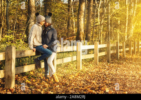 Junges Paar Tragen warme Pullover und Wolle Hüte im Park am sonnigen Herbsttag Stockfoto