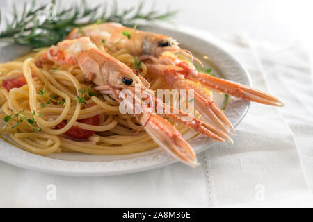 Langustinen, auch genannt Scampi oder Kaisergranat, auf ein mediterranes Essen Spaghetti mit Tomaten, Knoblauch, Parmesan und Kräuter, teuer, aber d Stockfoto