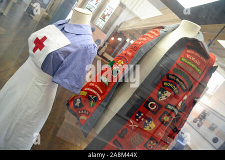 Krankenschwestern Uniform und ein dekoriertes Hemd oder eine Jacke, im Royal Victoria Military Hospital, Chapel Museum, Royal Victoria Country Park, Netley, Hampshire, Großbritannien Stockfoto