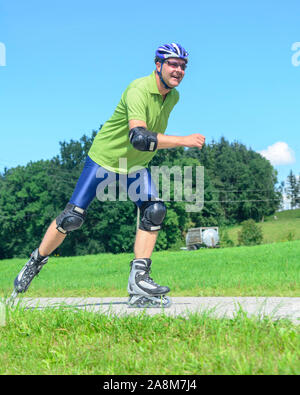 Mann eine skating Tour auf Inline Skates in der grünen Natur Stockfoto