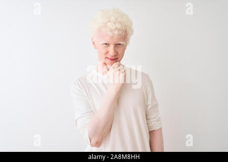 Junge albino blonder Mann legere t-shirt stehend über isoliert weißer Hintergrund in die Kamera schaut zuversichtlich mit Smile mit verschränkten Armen und Stockfoto
