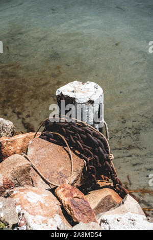 Detail Schuß von Kette und Festmachen post am Fluss in der Nähe der Dunbogan Boot vergossen und Marina an einem sonnigen Tag. Stockfoto