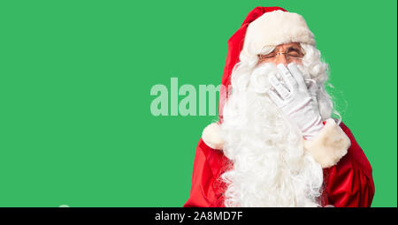 Mittleres Alter stattlicher Mann mit Santa Claus Kostüm und Bart stand gelangweilt Gähnen müde über den Mund mit der Hand. Rastlos und Schläfrigkeit. Stockfoto