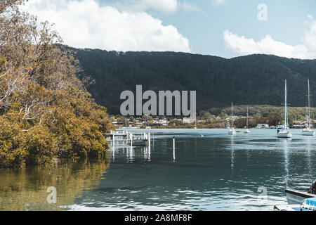 Dunbogan Boatshed, NSW, Australien - 20. Oktober 2019: Landschaftlich schöne Aussicht auf die Boote auf dem ruhigen Camden Haven Einlass-/Fluss. Stockfoto