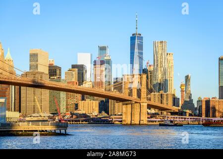 Brooklyn Bridge im Morgenlicht, Blick von der Hauptstraße über den East River Park auf die Skyline von Manhattan mit Freedom Tower oder eine Welt Stockfoto