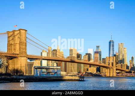 Brooklyn Bridge im Morgenlicht, Blick von der Hauptstraße über den East River Park auf die Skyline von Manhattan mit Freedom Tower oder eine Welt Stockfoto