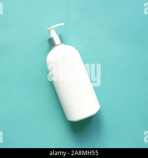 Weiß Dispenser auf blauem Hintergrund, Ansicht von oben, kopieren. Leere Flasche aus Kunststoff Pumpe für Shampoo und Creme oder Seife, Hautpflege Konzept. Stockfoto