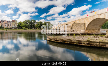 Regensburg 2019. Donau und steinerne Brücke in langen Belichtungszeit. Leute, die vor kurzem restaurierte Brücke in die Altstadt zu kommen. August 2019 in Regensburg. Stockfoto