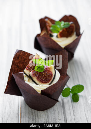 Cupcakes mit Feigen auf einem weißen Holz- Hintergrund Stockfoto