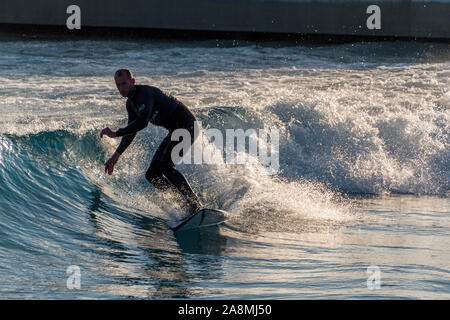 Surfer reiten Erweiterte ebene Wellen an der Welle, Bristol, eine künstliche Binnen surfen See in der Nähe von Bristol, UK. Stockfoto