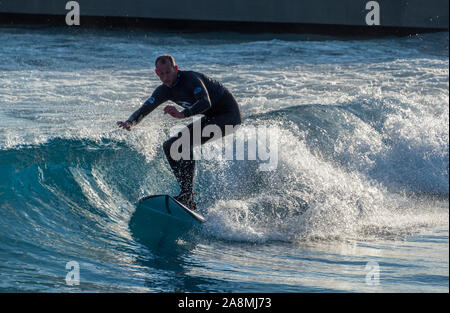 Surfer reiten Erweiterte ebene Wellen an der Welle, Bristol, eine künstliche Binnen surfen See in der Nähe von Bristol, UK. Stockfoto