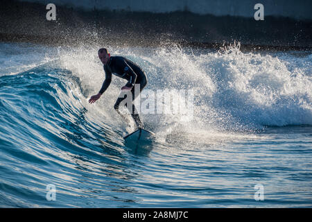 Surfer reiten Erweiterte ebene Wellen an der Welle, Bristol, eine künstliche Binnen surfen See in der Nähe von Bristol, UK. Stockfoto