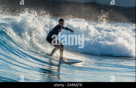 Surfer reiten Erweiterte ebene Wellen an der Welle, Bristol, eine künstliche Binnen surfen See in der Nähe von Bristol, UK. Stockfoto