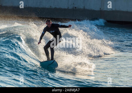 Surfer reiten Erweiterte ebene Wellen an der Welle, Bristol, eine künstliche Binnen surfen See in der Nähe von Bristol, UK. Stockfoto