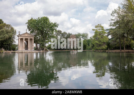 Panoramablick auf den Tempel des Asklepios (Tempio di Esculapio) und See in den öffentlichen Park der Villa Borghese. Tag Sommer und blauer Himmel Stockfoto