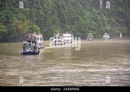 Editorial: Guilin, Guangxi, China, April 19, 2019 - Touristen auf dem Deck der River Cruise Boote auf dem Li River in der Nähe von Guilin gesammelt Stockfoto