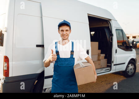 Deliveryman in Uniform zeigt Daumen hoch, Lieferung Stockfoto