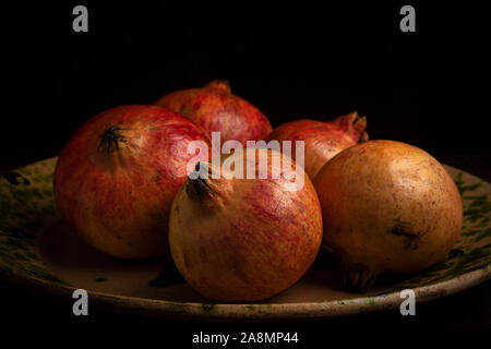 Granatäpfel an eine alte Platte. Stockfoto