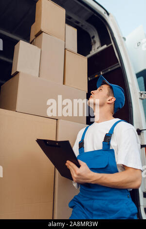 Deliveryman in Uniform, Pakete im Auto, Cargo Stockfoto