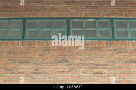 Gestreifte Wände aus Backstein und Holz- Fenster wird als Hintergrund verwendet. Stockfoto