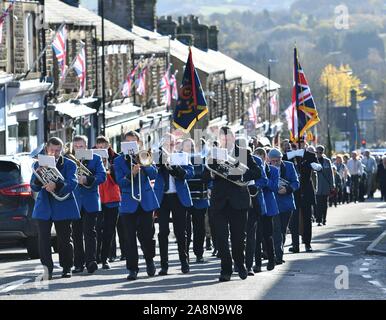 10. November 2019 neue Mühlen, Derbyshire. Eine Band führt die Erinnerung Tag der Parade auf der Union Street von St George's Parish Church in die Gedenkstätte in der Lea Park. Stockfoto