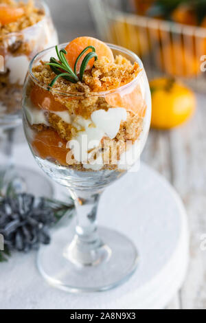 Citrus Kleinigkeit mit Karotte Keks und frische Mandarinen in einem Glas. Weihnachten portioniert Dessert auf der festlichen Tafel. Stockfoto