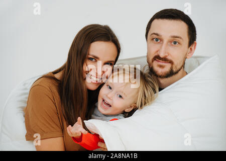 Porträt einer glücklichen Familie in eine Decke gewickelt. Mutter, Vater und Sohn. Stockfoto