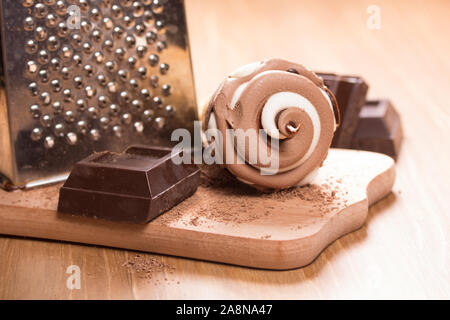 Eis und Stücke von dunkler Schokolade auf dem Tisch Stockfoto