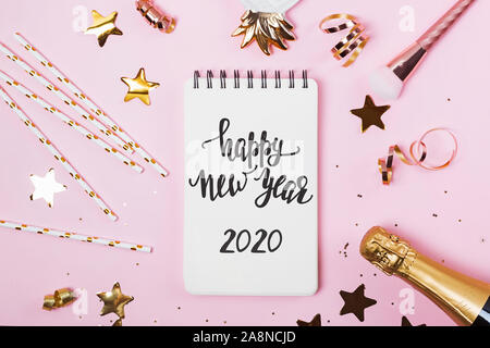 Notizblock mit mit Text ein Frohes Neues Jahr 2020 auf rosa Hintergrund mit goldenen Konfetti, Glitter und andere Stockfoto