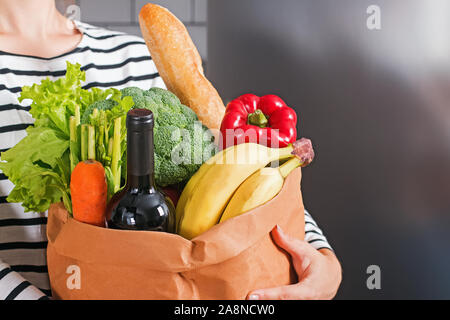 Frau mit eco-Papier Tüte voller Produkte von lokalen Speicher Stockfoto