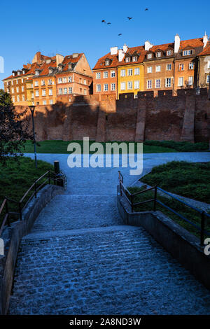 Gasse in der Altstadt von Warschau bei Sonnenuntergang, Hauptstadt von Polen, historische Häuser hinter der Stadtmauer. Stockfoto