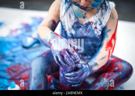 Eine entzückende kleine Kleinkind, Mädchen hat Spaß beim Spielen mit Farben malt, unordentlich und haben viel Spaß, in einer familiären Umgebung Schuß Stockfoto