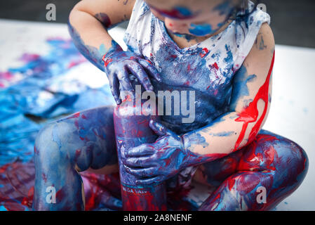 Eine entzückende kleine Kleinkind, Mädchen hat Spaß beim Spielen mit Farben malt, unordentlich und haben viel Spaß, in einer familiären Umgebung Schuß Stockfoto