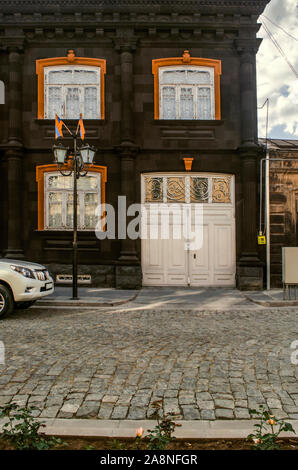 Die ecke Teil des Hauses mit klassischen Säulen und geschnitzten Gesims aus schwarzem Tuff und mit rotem Stein Frames auf dem Windows mit Iro abgedeckt Stockfoto