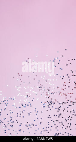 Sternförmige Konfetti auf Pastell rosa Hintergrund Stockfoto