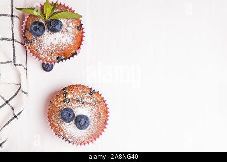 Leckere Muffins mit Heidelbeeren auf die weiße Holztisch Stockfoto