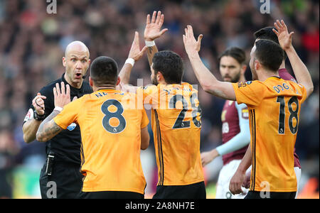 Wolverhampton Wanderers" Ruben Neves, Raul Jimenez (Mitte) und Diogo Jota (rechts) argumentieren mit Schiedsrichter Anthony Taylor (links) Während der Premier League Spiel im Molineux, Wolverhampton. Stockfoto