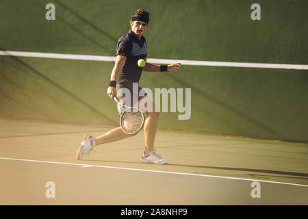 Professional tennis player schlagen eine starke Rückhand während eines Spiels. Tennis Player spielen auf einem Hartplatz. Stockfoto