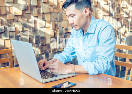 Junge asiatische Geschäftsmann, der an einem Notebook arbeitet Stockfoto