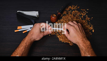 Man macht eine Zigarette mit rollenden Maschine, Hände, Nahaufnahme Stockfoto